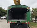 A 2015 Freightliner M2 106 truck with a green body and an empty cargo area featuring yellow hydraulic lift arms at the back