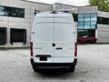A white 2020 Mercedes-Benz Sprinter van viewed from the rear with a roof rack and the model name displayed on the back