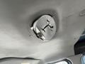 A disassembled dome light fixture on the ceiling of a 2009 Ford Econoline van