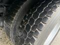 Close-up of a textured tire from a 2003 Freightliner FL70 showing worn treads and grooves