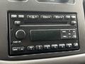 Close-up of a car radio system featuring various buttons for controls like volume, tuning, and CD functions with a simplistic black design