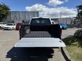 A 2016 Ford F-150 with an open tailgate and a black lined truck bed, viewed from the rear