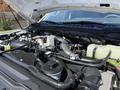 The image shows the engine compartment of a 2023 Ford F-550 with various components including hoses, a coolant reservoir, and an exposed engine block