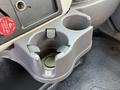 A close-up of a gray cup holder with a circular base and a small clip for securing items in a 2011 International 7500 vehicle interior