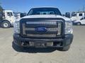 A white 2014 Ford F-250 Super Duty truck with a black grille and the Ford logo prominently displayed in the center