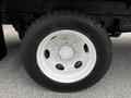 Wheel of a 2018 Isuzu NPR with a white rim and five visible lug nuts on a black tire