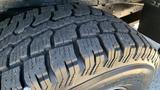 Close-up of a rugged tire tread on a 2013 Ford Econoline showcasing deep grooves and patterned rubber designed for traction and durability