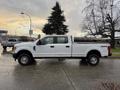 A white 2017 Ford F-350 Super Duty truck with a crew cab and 4x4 emblem visible on the side parked on a street