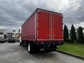 A red 2008 Ford F-750 box truck with a closed back and a flatbed design parked on a lot