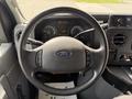 A 2010 Ford Econoline steering wheel with a Ford logo and various controls visible on the dashboard and instrument panel