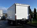 A white 2020 Isuzu NPR box truck with a solid rear panel and no visible markings