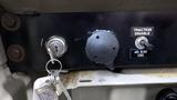 Close-up of the dashboard controls of a 2003 International 5600i featuring a key ignition switch a traction disable switch and a button for the ABS blink code