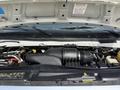 The image shows the engine compartment of a 2010 Ford Econoline with various components like the air intake hose and battery visible