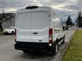 A 2020 Ford Transit van in white parked on the street with a plain rear view showcasing the vehicle's cargo area and back lights