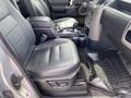 Interior of a 2006 Land Rover LR3 featuring black leather seats a central console and floor mats with a gear shift and cup holders in the front cabin