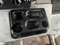 A black plastic console tray with four cup holders designed for a 2012 Workhorse W62 vehicle