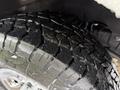Close-up of a rugged tire with deep treads on a 2021 Chevrolet Express showing water droplets on the surface