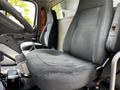 A gray fabric driver's seat in a Freightliner M2 106 truck interior with a second gray seat visible next to it
