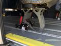 A 2016 RAM Promaster vehicle featuring a sturdy metal bracket with red and black supports mounted on the floor for attaching seating or equipment