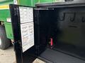 A black storage compartment door of a 2015 Freightliner M2 106 with a chart inside and several hooks mounted on one side