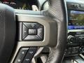 A close-up of the steering wheel controls of a 2019 Ford F-150 featuring volume and mode buttons