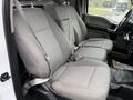 Interior view of a 2018 Ford F-150 showing two front seats with gray fabric upholstery and seatbelts attached
