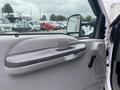 The interior door handle of a 2003 Ford F-450 SD showing a silver finish and textured surface with part of the vehicle's door panel visible