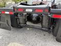 A 2012 Volvo VNL truck's rear suspension system with air springs and dual tires visible, featuring the Volvo logo on the components