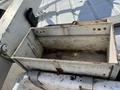 A metal storage box with rusted edges sits empty on a flat surface