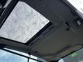 Interior view of a 2024 Caterpillar 306 with an open sunroof showcasing the ceiling design and overhead features