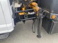A 2017 Ford F-550 with hydraulic connections and a black dump bed attachment visible in the foreground