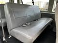 A gray leather bench seat from a 2004 Ford Econoline van with seatbelts attached