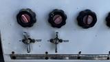 Control panel with three round black knobs and two silver levers labeled for pressure release and on/off functions