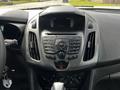 The dashboard of a 2016 Ford Transit Connect featuring various buttons and controls for radio media and climate along with a digital display