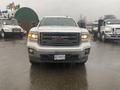 A 2015 GMC Sierra 1500 pickup truck facing the viewer with a white exterior and a black grille featuring the GMC logo