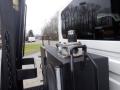 A close-up of a hydraulic reservoir on a 2010 International 7300 showing a metallic cap and fittings