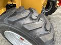 A close-up of a large, rugged tire with deep treads designed for a 2024 AGT Industrial KRW23 Mini Loader