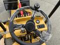 The steering wheel and control panel of a 2024 AGT Industrial KRW23 Mini Loader with protective plastic wrap on the steering wheel