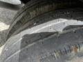 A close-up view of worn tires from a 2004 Toyota Toyoace with visible tread wear and cracks in the rubber