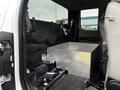 A 2016 Ford F-150 with a storage box made of diamond plate metal positioned in the back seat area