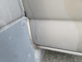 Close-up view of the door seal and corner trim on a 2020 Chevrolet Express showing signs of wear and dirt accumulation