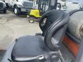 A black seat of a 2010 Toyota 7FGGU25 forklift with a high back and ergonomic design visible in the foreground