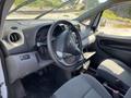 Interior view of a 2019 Nissan NV200 showing the steering wheel dashboard and front seats in gray upholstery