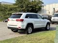 A white 2020 Jeep Grand Cherokee parked with its rear visible showcasing its sleek design and distinctive Jeep branding