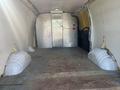 Interior view of a 2013 Chevrolet Express cargo van showing an empty space with wooden flooring and metal dividers
