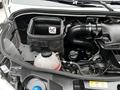 A 2020 Mercedes-Benz Sprinter engine compartment featuring a black air filter box a coolant reservoir and various engine components and hoses