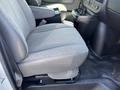 A gray fabric driver's seat from a 2012 Chevrolet Express with armrests and a console beside it