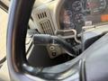 Close-up of the steering wheel and gear shift lever of a 2009 International 7500 with various gauges visible in the background