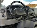 Interior of a 2013 Ford Econoline showing the steering wheel dashboard controls and key in the ignition