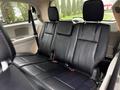 Interior view of a 2017 Dodge Grand Caravan showing black leather rear seats with seat belts and a spacious design